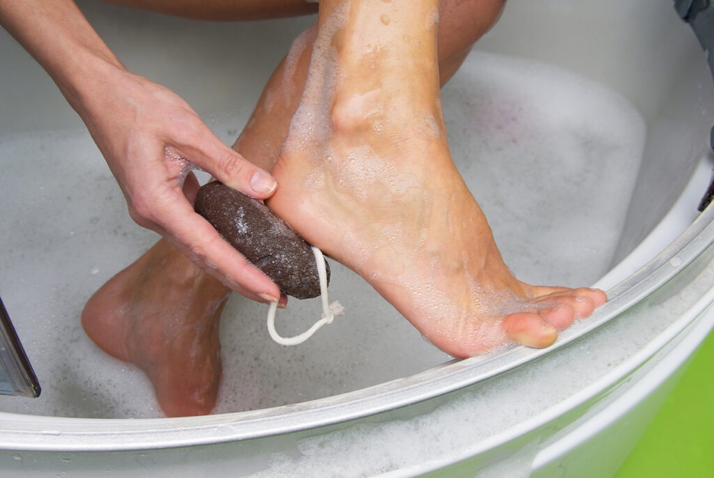 using a pumice stone on the soles of the foot