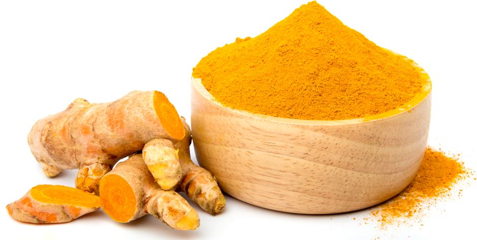 fresh turmeric and turmeric powder in a wooden cup