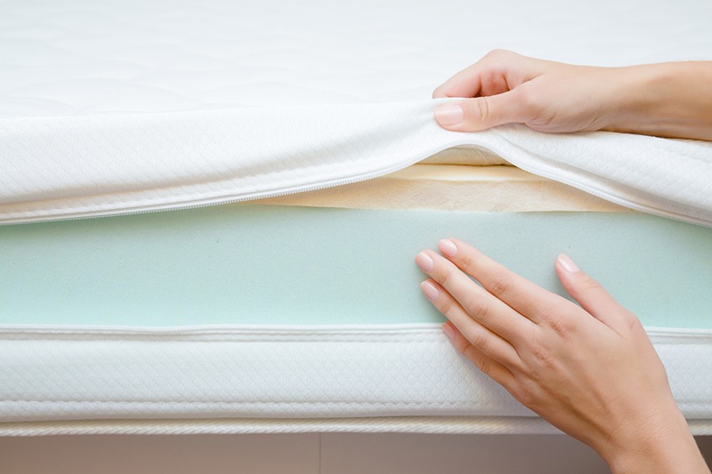 person touching a polyfoam mattress