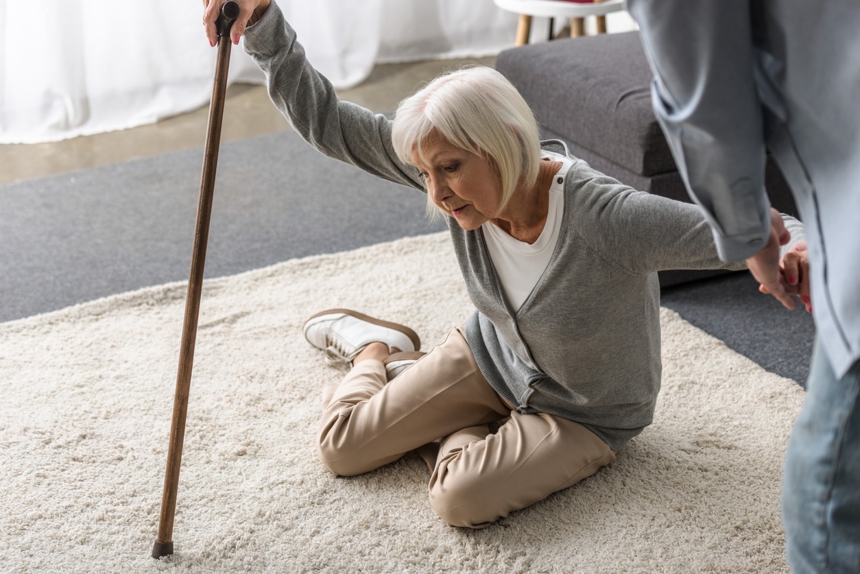 caregiver assisting an elderly woman on the floor
