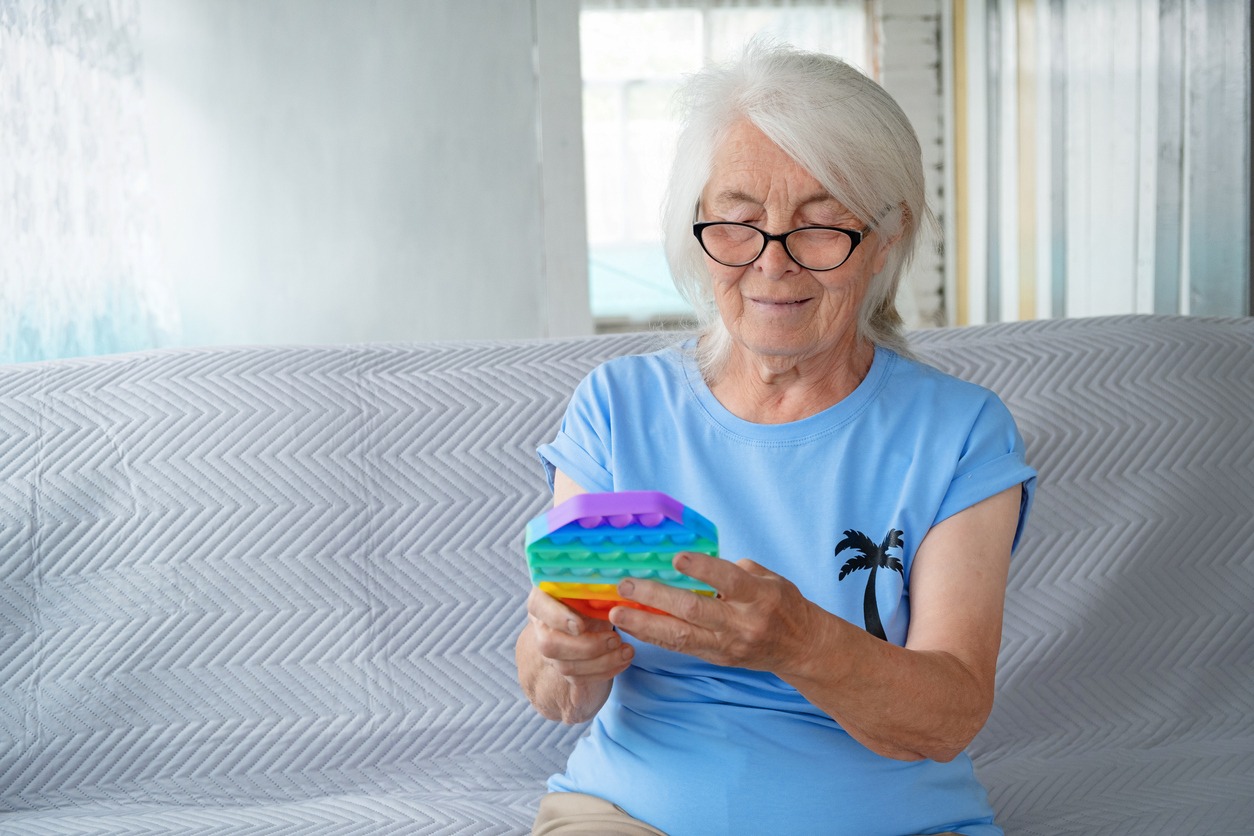 elderly woman playing with a pop fidget toy
