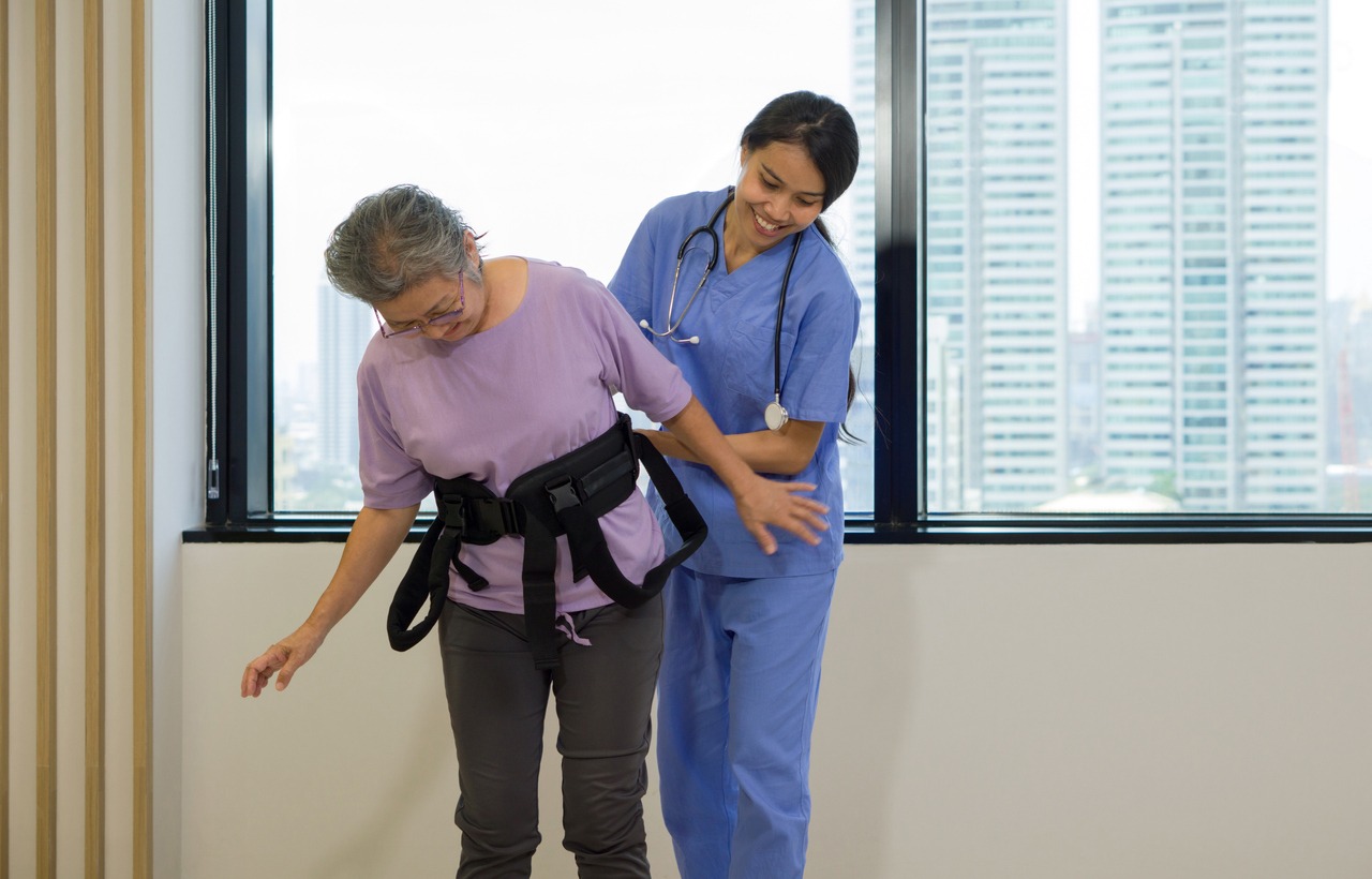 a caregiving assisting an elderly woman to walk using a gait belt