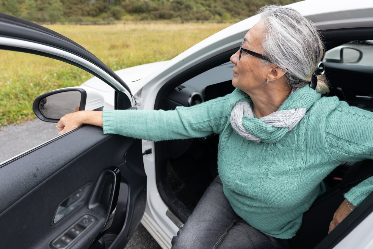 a senior woman getting out of a car