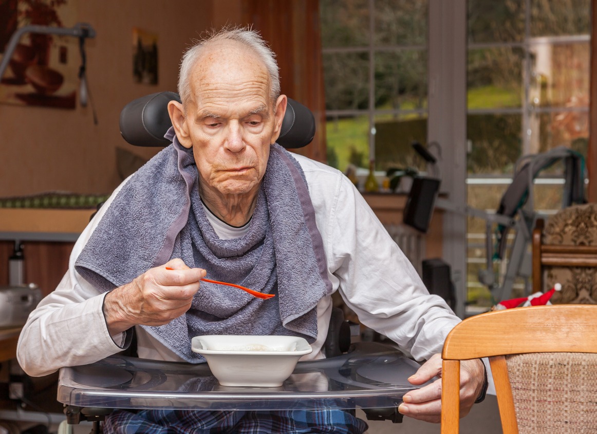 an elderly man eating a meal