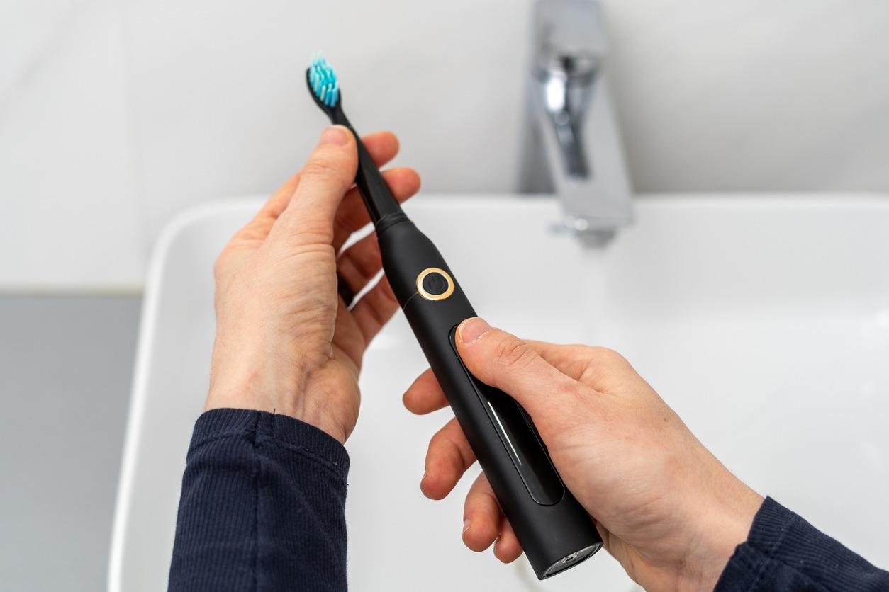 person holding an electric toothbrush