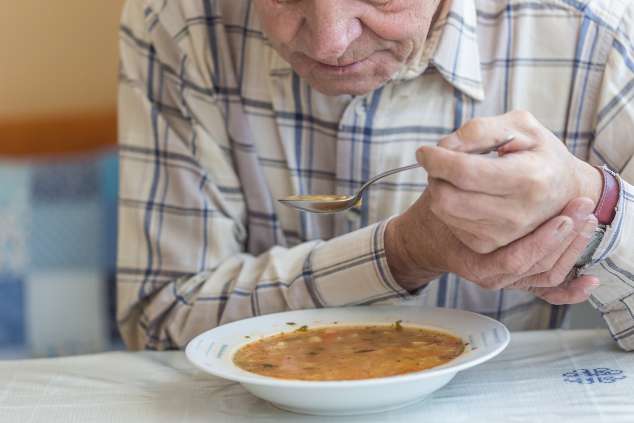 man with Parkinson’s disease eating soup