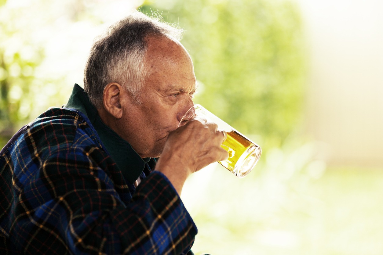 a senior man drinking beer