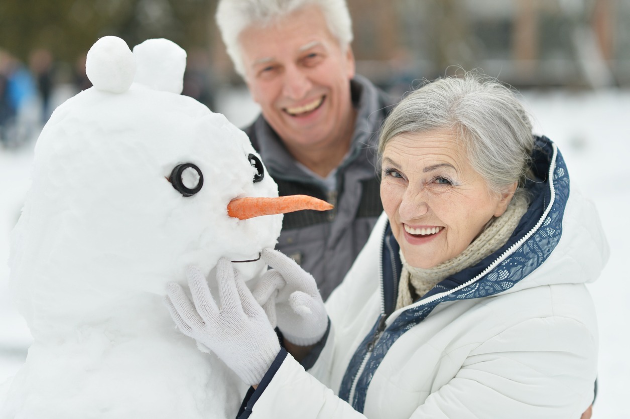 senior couple making a snowman