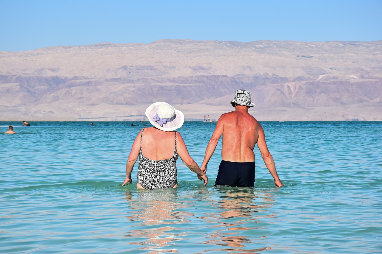 elderly couple wading in seawater
