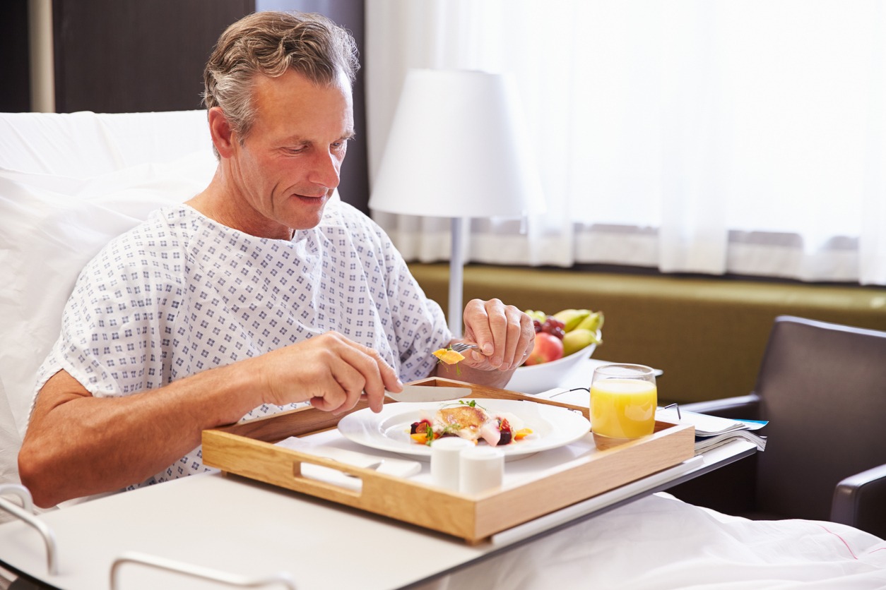man eating on an overbed table
