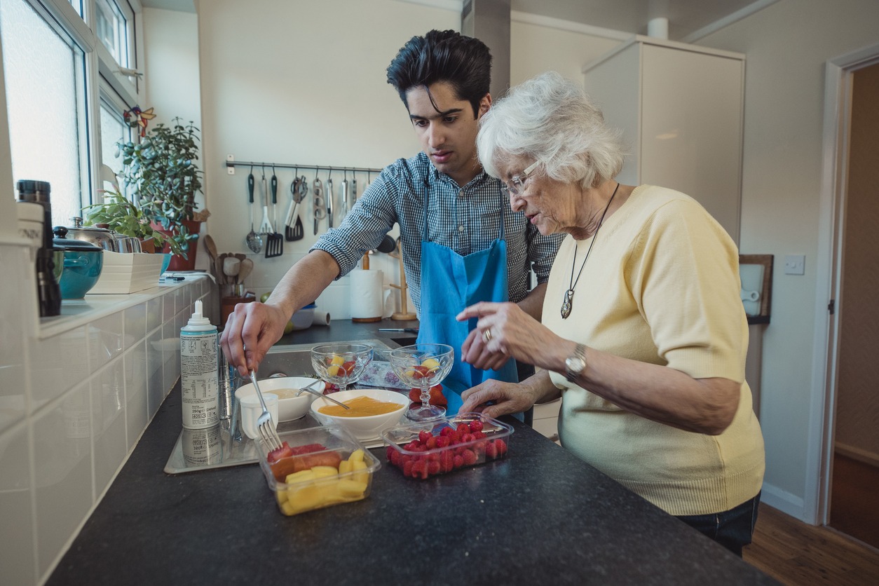 man preparing food with a senior woman