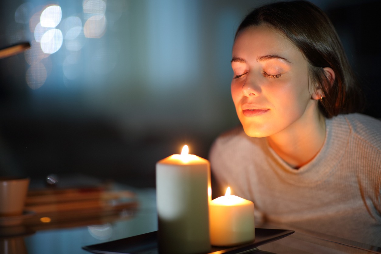woman smelling scented candles