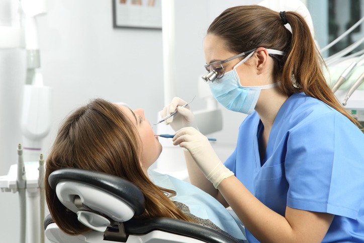a dentist examining the teeth of her patient