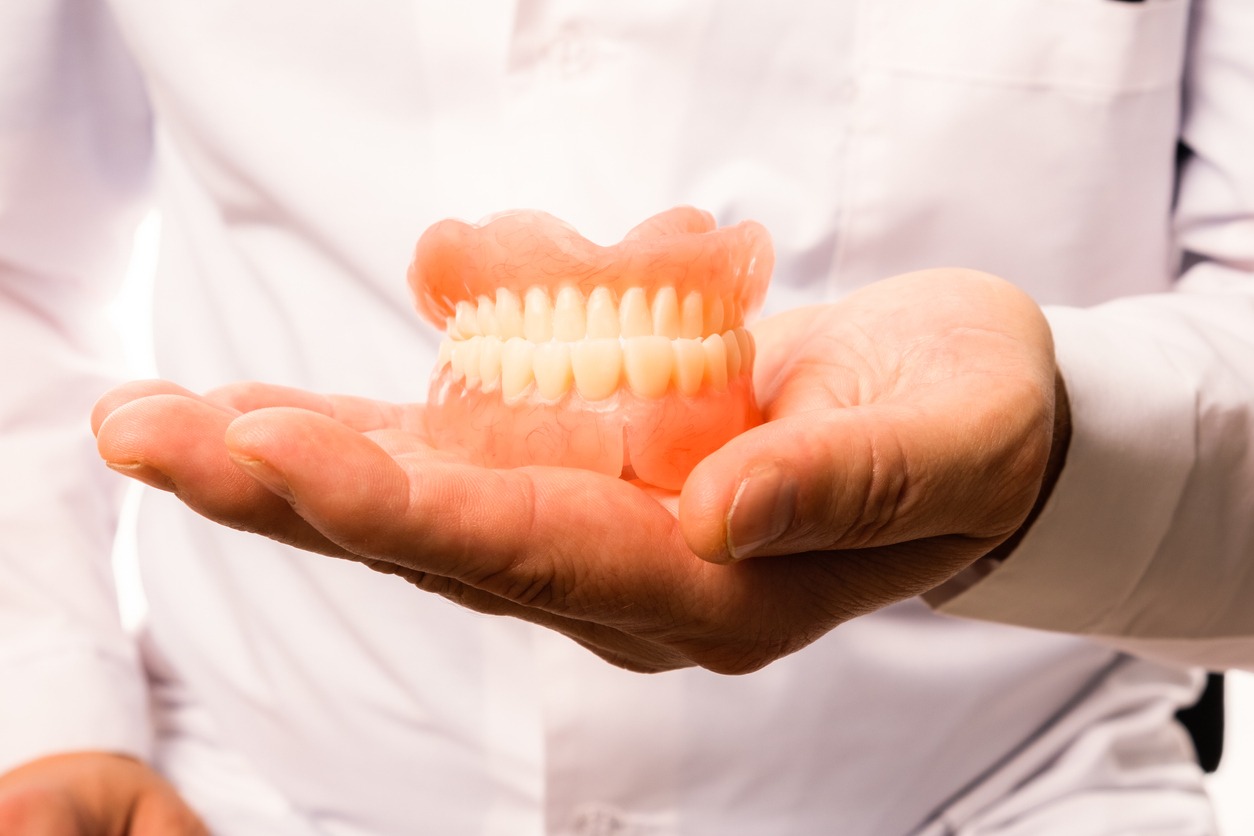dentist holding a gum and teeth model