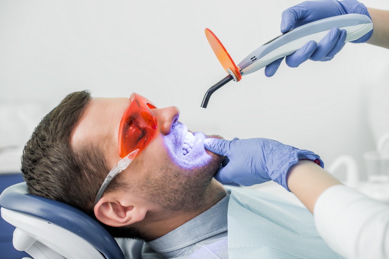 man undergoing a teeth-whitening treatment in the dental clinic