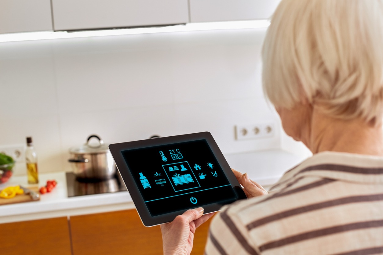 senior woman using a tablet to control her smart home
