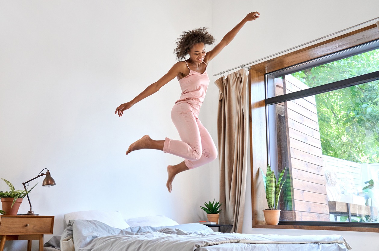 woman jumping on the bed
